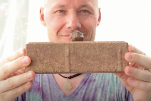 A faculty member holds a rock sample