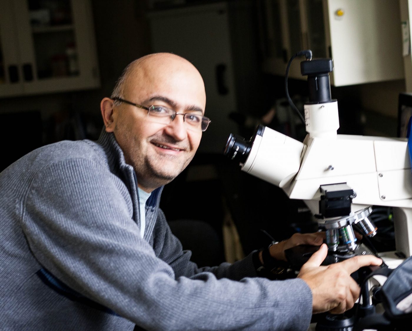 Alfonso Abizaid next to a microscope