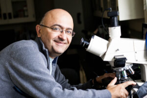 Alfonso Abizaid next to a microscope