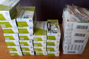 Boxes of nitrile gloves and N95 masks in a pile to be donated.