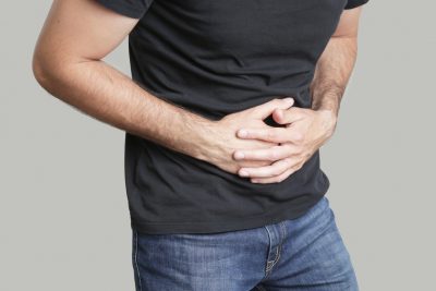 Image of a man having painful stomach ache, chronic gastritis or abdomen bloating
