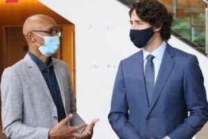 A student speaks with Prime Minister Justin Trudeau while both wear masks