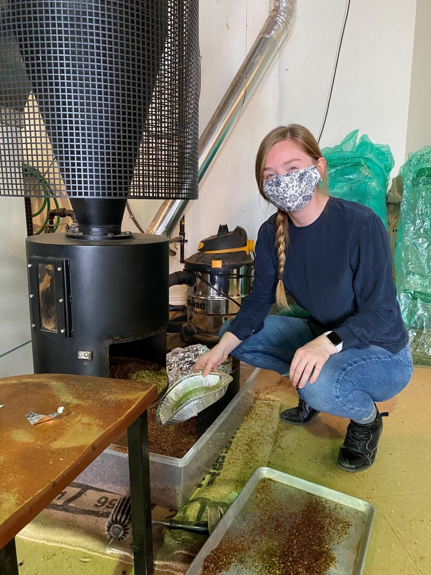 Kim McDonald collecting silverskin from roaster.