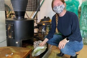 Kim McDonald collecting silverskin from roaster.